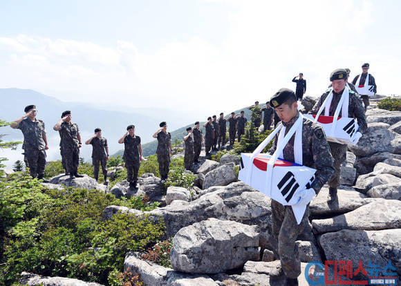 산에서 발굴된 유해들이 한국군 병사들에 의해 산 아래로 내려오고 있다. 유해발굴 작업은 엄청난 인력이 투입되어 오랜 기간동안 진행되는 작업이다. 